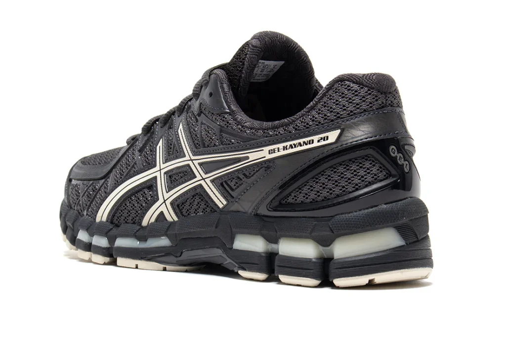 Rear three-quarter angle of the GEL-KAYANO 20 revealing the sculpted heel counter, view GEL cushioning pods, and silver branding along the sidewall. The technical architecture emphasizes stability and show heritage