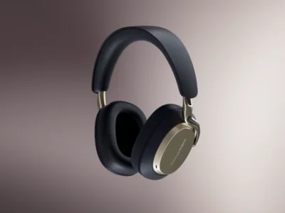 Bowers & Wilkins over-ear wireless headphones in a light mist-gray finish, suspended against a neutral gradient backdrop, showcasing the sleek silhouette and premium material