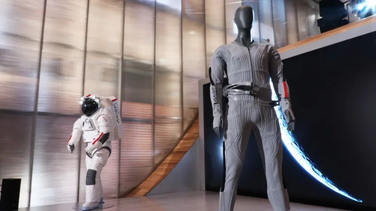 Prada x Axiom Space Liquid Cooling and Ventilation Garment (LCVG) displayed alongside the AxEMU spacesuit at the official reveal for NASA’s Artemis lunar mission