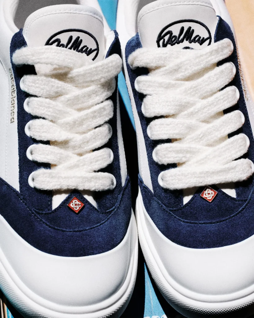 Detailed close-up of the navy-and-white Casablanca Del Mar colorway, focusing on the plush white laces, navy suede overlays, embroidered tongue branding, and sculpted white toe caps