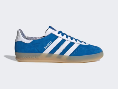 Side profile of the adidas Gazelle Indoor x Mercedes-AMG PETRONAS Formula One Team sneaker in bright blue suede with white leather Three Stripes, blue laces, a translucent gum sole, and Gazelle brand