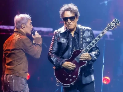 Journey performs live on the Final Frontier Tour 2026 as the lead vocalist sings beside the guitarist under colorful arena stage light
