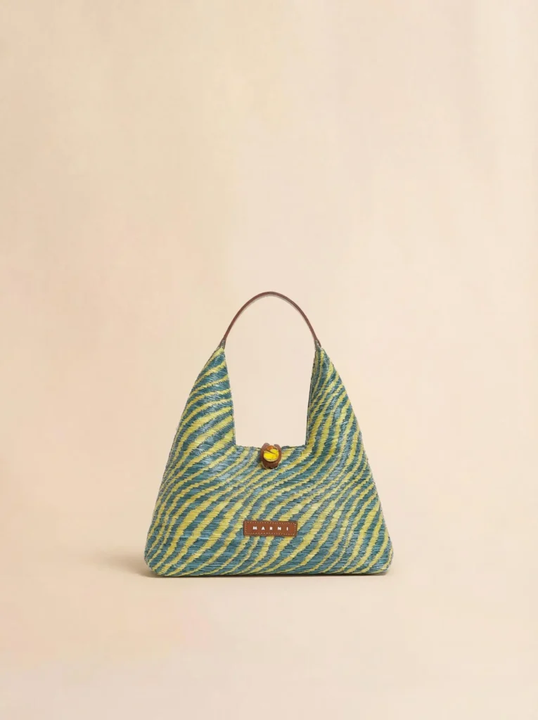 A compact Marni shoulder bag featuring the same blue-and-green woven zigzag motif. Its soft triangular silhouette is finished with a single top handle and a decorative button closure