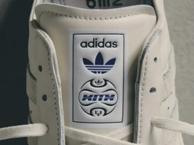 Close-up of a cream Kith x adidas sneaker tongue showcasing adidas Originals branding above a custom Kith co-branded emblem