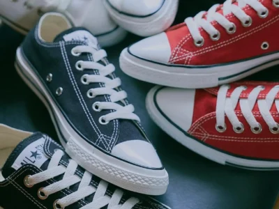 Assorted Converse Chuck Taylor shoe in black, white, and red colorways arranged together, highlighting the collection’s versatile styling option