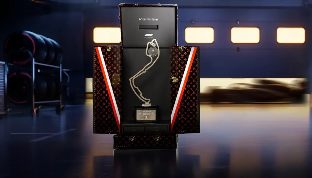 Louis Vuitton Formula 1 Trophy Trunk opened to reveal the championship trophy presentation inside a professional racing garage environment
