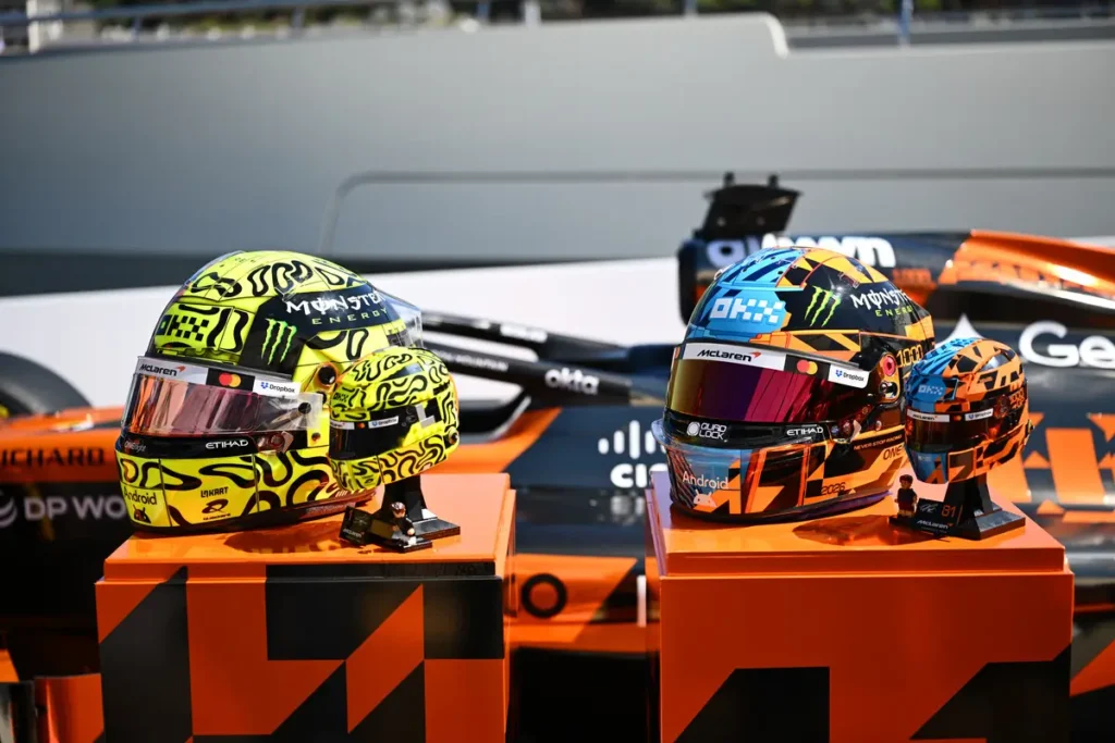 Official McLaren driver discussing the collaboration while LEGO helmet models are exhibited beside the Formula 1 car in a marina set