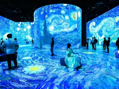 Guests explore a large-scale digital art environment filled with swirling blue projections inspired by Vincent van Gogh’s The Starry Night, extending across every surface