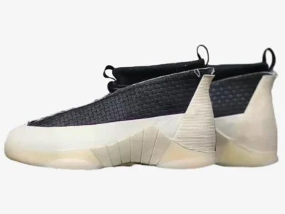 Lateral side view of the shoe pair highlighting the woven black textile upper, textured cream heel support, sculpted midsole geometry, and vintage-tinted translucent outsole