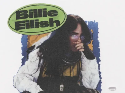 Close-up detail of the Billie Eilish graphic print featuring a vintage concert-style portrait, green oval logo, layered textures, and distressed tour merchandise aesthetic