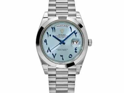 Front view of a Rolex Day-Date featuring an ice-blue sunburst dial with oversized Arabic numerals, blue hands, day window at 12 o’clock, date magnifier, and a platinum President bracelet
