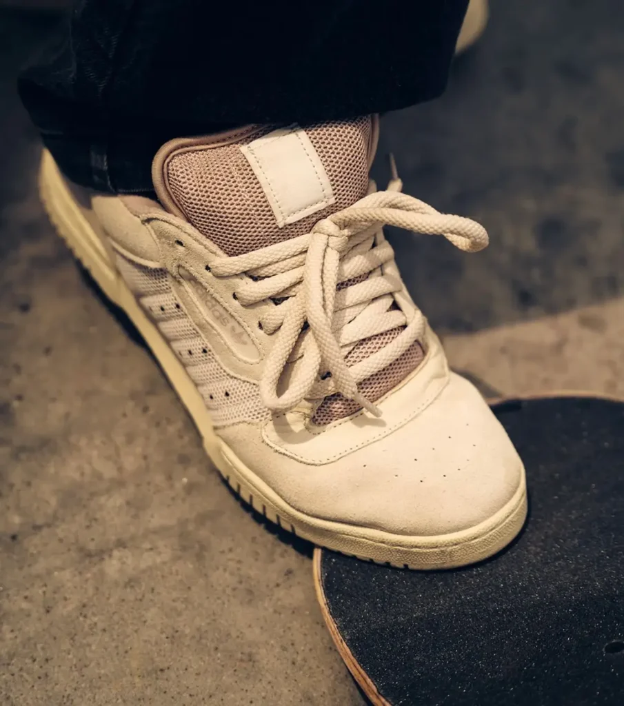 A skater adjusts the brown Powerphase before a session, drawing attention to the padded mesh tongue, oversized laces, and supportive low-cut design