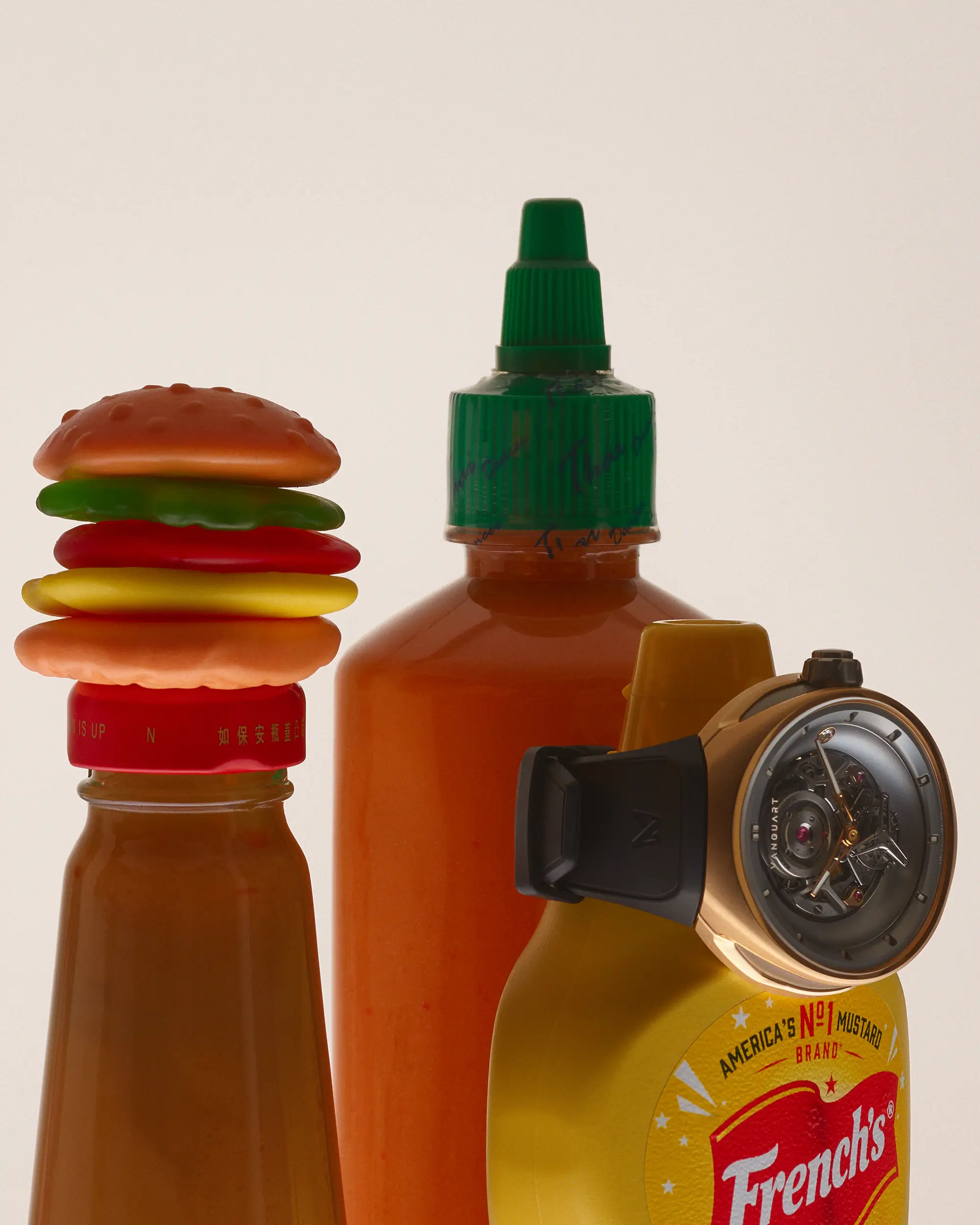 Vanguart watch positioned alongside hot sauce and mustard bottles, accompanied by a miniature toy hamburger. Bright condiment colors emphasize the watch’s contemporary, playful aesthetic