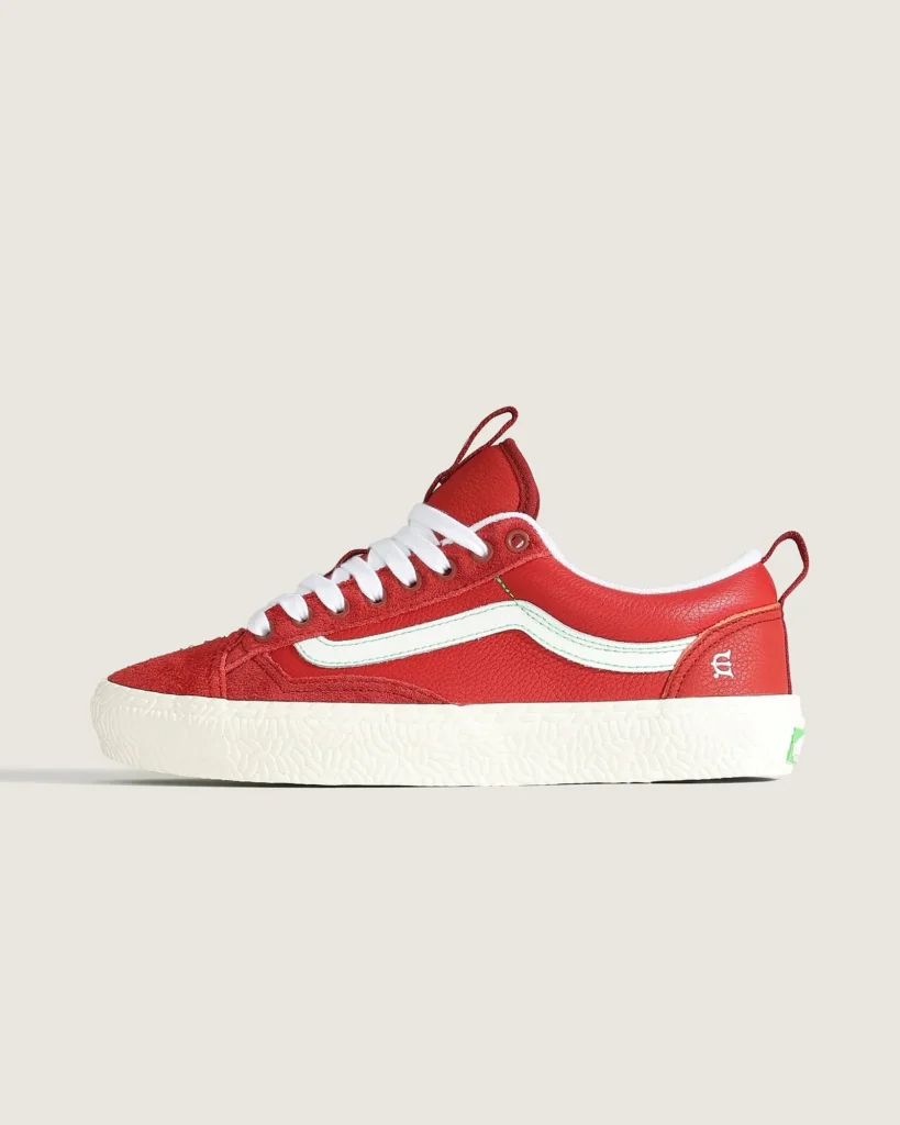 Side profile of the Vans Skate Old Skool 36+ x Evisen Skateboards shoe in bright red suede and leather with a white side stripe, textured white foxing, and green outsole accent