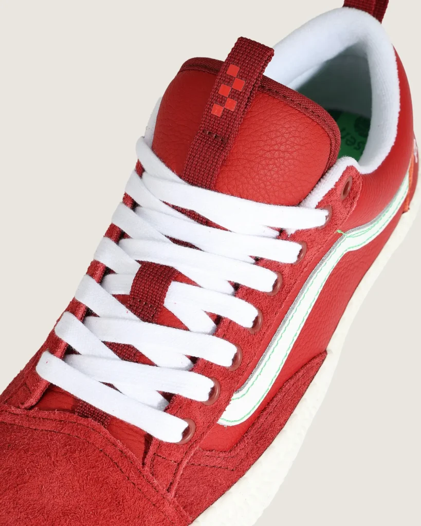 Detailed look at the red leather tongue and white laces of the Vans Skate Old Skool 36+ Evisen Skateboards shoe, showcasing premium textures and pull-tab accent