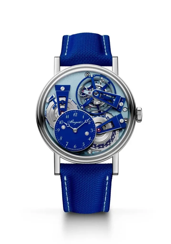 Breguet mechanical wristwatch with an openworked blue movement, offset enamel time display, visible gears, polished case, and textured blue fabric strap