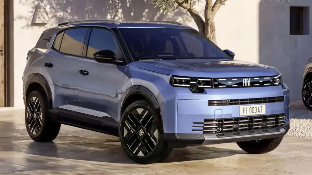 Light blue Fiat Grizzly compact SUV concept shown from the front three-quarter angle in a sunlit courtyard. The design combines a boxy silhouette, slim LED lighting, black roof treatment, and geometric alloy wheels for a rugged urban look