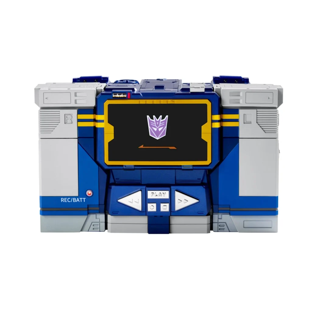 Front view of Soundwave’s cassette player form displaying playback buttons, status indicator light, cassette-deck styling, and a digital Decepticon emblem screen