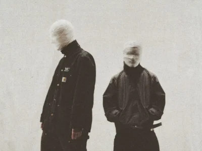 Moody press visual for Larry June’s “The Machinist” era – bandaged figures in dark streetwear evoke raw, anonymous West Coast energy and cinematic grit