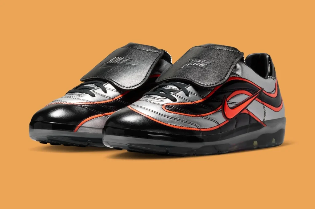 Angled product shot of the Patta x Nike Cryoshot Mercurial R9 against a warm orange backdrop, emphasizing its football-inspired silhouette, glossy finishes, and translucent cushioning platform