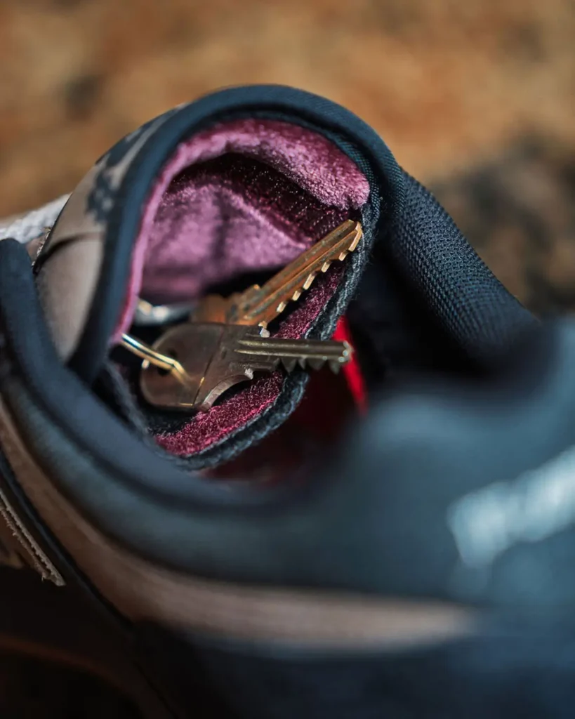 Close-up view inside a New Balance Numeric 480 sneaker reveals a pair of metal keys tucked into the plush burgundy velvet lining, highlighting a hidden storage compartment inspired by skate culture and road-trip essential