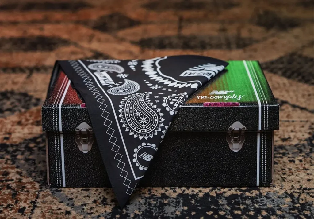 A custom black storage box featuring paisley graphics and No-Comply branding is displayed with a folded bandana draped across the lid, emphasizing the project’s Western-inspired storytell