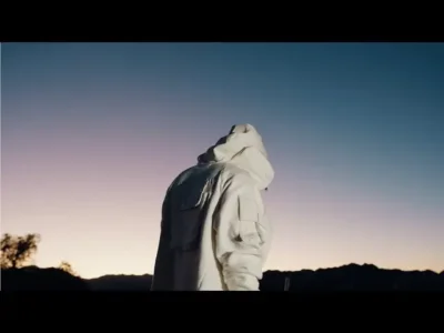 NoCap stands reflective in the desert dusk for his “Leverage” view — a moody symbol of success, solitude, and elevation ahead of Heaven on Mars