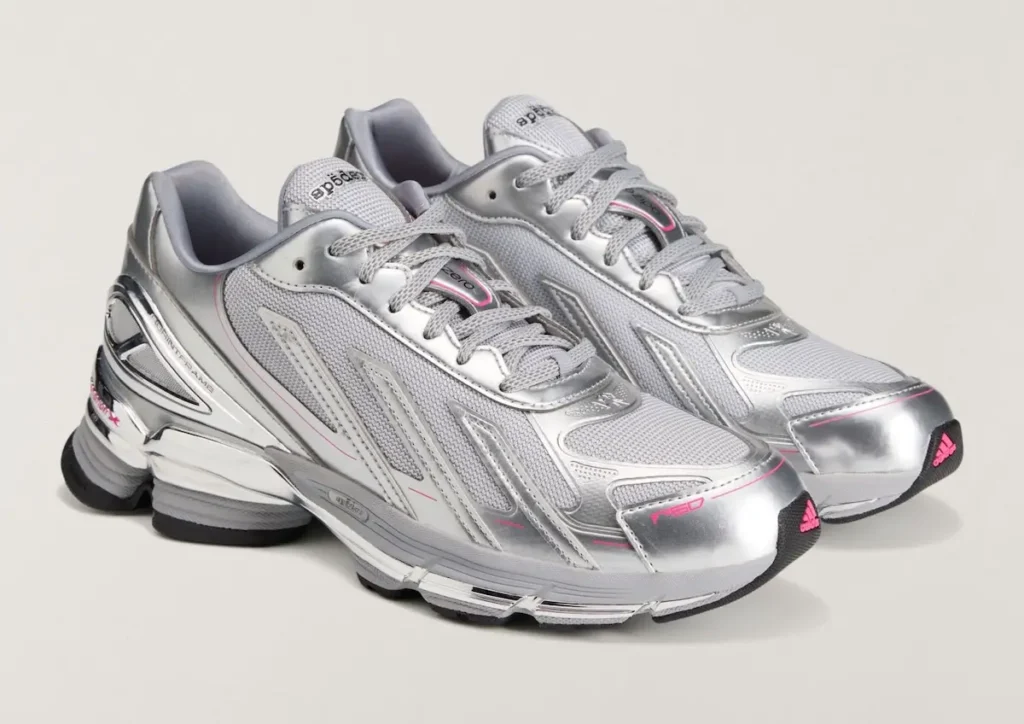 Three-quarter angled view of the pair displaying the streamlined F50-inspired silhouette. Metallic silver overlays contrast with breathable mesh panels, while pink adidas branding on the toe bumper adds a vibrant accent