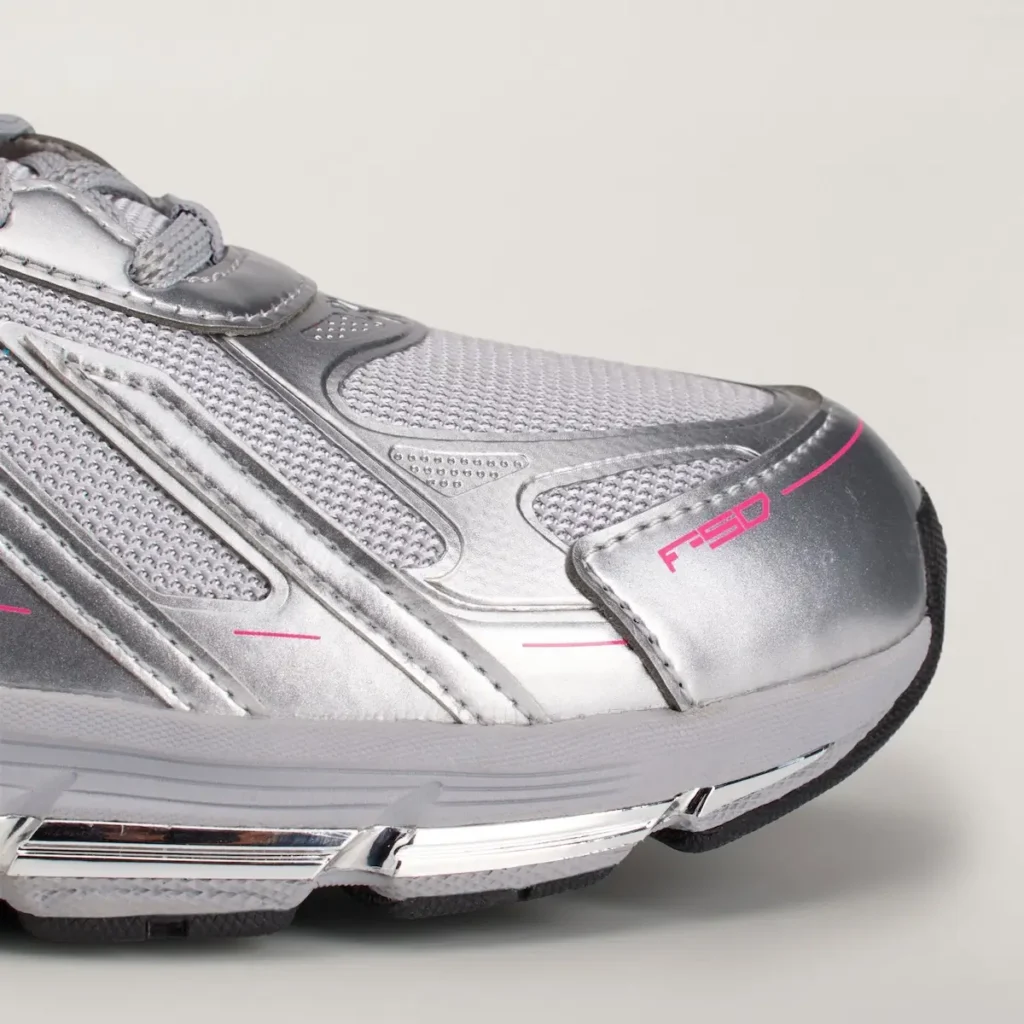 Close-up detail of the forefoot area featuring metallic silver overlays, textured mesh construction, pink F50 branding on the toe cap, and chrome midsole accents that enhance the futuristic appearance