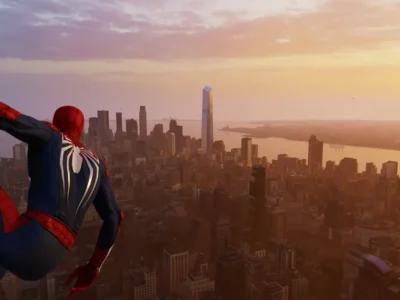 Spider-Man crouches high above New York City at sunset, overlooking a sprawling skyline bathed in warm golden light. Wearing a classic red-and-blue suit with a large white spider emblem on the back, he clings to the side of a skyscraper while gazing across the Hudson River and the city’s towering buildings stretching into the horizon. The scene captures a quiet, reflective moment before the hero swings back into action
