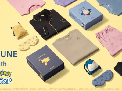 Flat lay promotional image showcasing the BAKUNE x Pokémon Sleep collaboration arranged on a soft yellow background. The collection includes pastel sleepwear sets, button-up pajamas, matching T-shirts and shorts, sleep masks, character-inspired drawstring pouches, and branded gift boxes featuring Pikachu and Snorlax artwork. The layout highlights the calming color palette and coordinated bedtime accessories