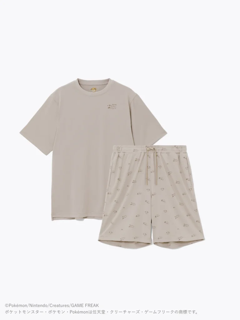 Studio product image of a beige BAKUNE x Pokémon Sleep sleepwear set with a loose-fitting crewneck T-shirt and matching drawstring shorts. A subtle chest graphic and scattered tonal Pokémon illustrations decorate the set, creating a minimalist look inspired by bedtime comfort and Pokémon Slee