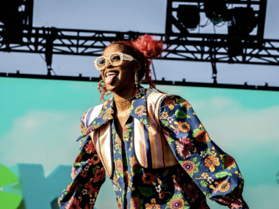 Tierra Whack live on stage in flow maximalist outfit and red hair during high-energy performance – clean editorial image from WAX PAPER era