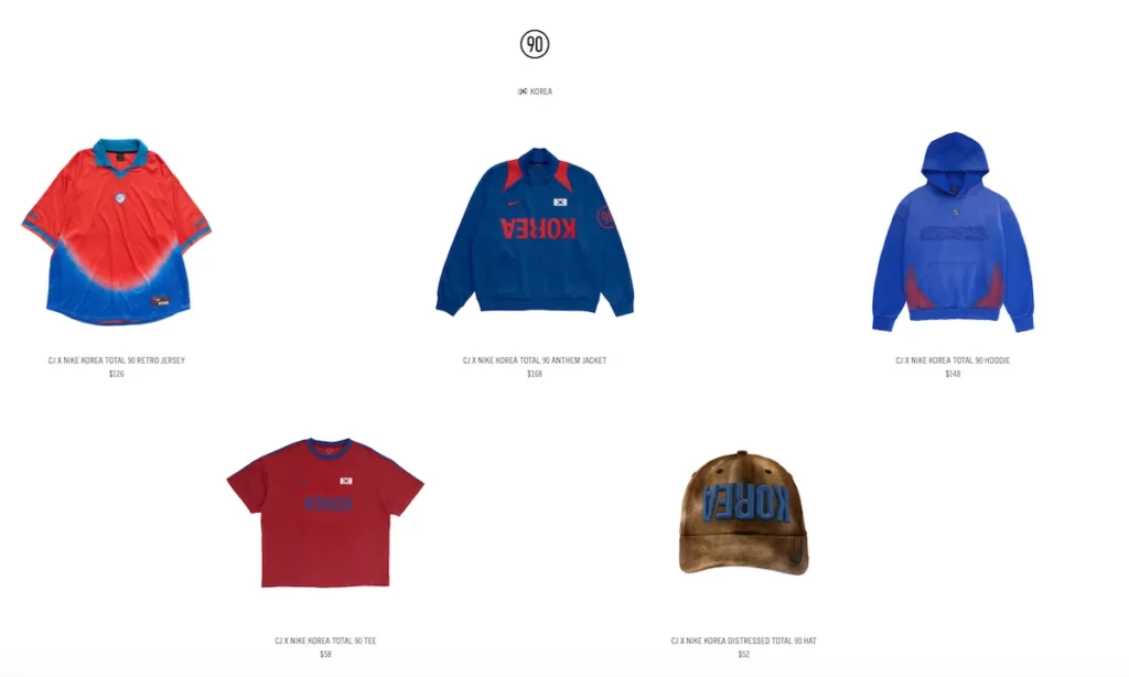 Cactus Jack x Nike Korea Total 90 capsule displaying a red-and-blue gradient football jersey, royal blue anthem jacket with inverted “KOREA” branding, blue hoodie with red accents, red training T-shirt, and a distressed brown cap with raised blue “KOREA” embroidery