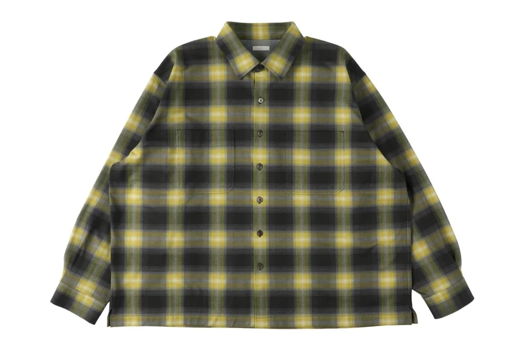 Oversized olive and charcoal plaid button-up overshirt featuring a soft brushed fabric, classic pointed collar, full front button closure, two oversized chest patch pockets, dropped shoulders, and a relaxed boxy sil
