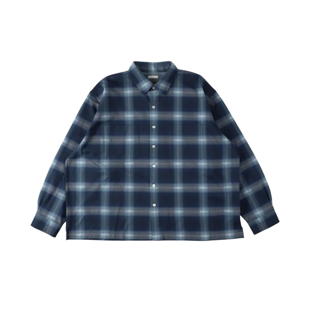 Relaxed navy plaid button-up overshirt with tonal blue and gray check pattern, brushed fabric construction, pointed collar, full button front, oversized chest patch pockets, dropped shoulders, and a loose boxy fit
