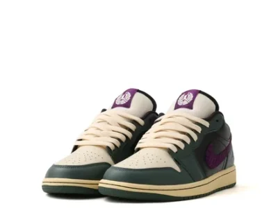 Three-quarter front view of the Air Jordan 1 Low showcasing a sail perforated toe box, dark green leather overlays, cream laces, purple woven Swoosh, and matching purple Jumpman tongue brand