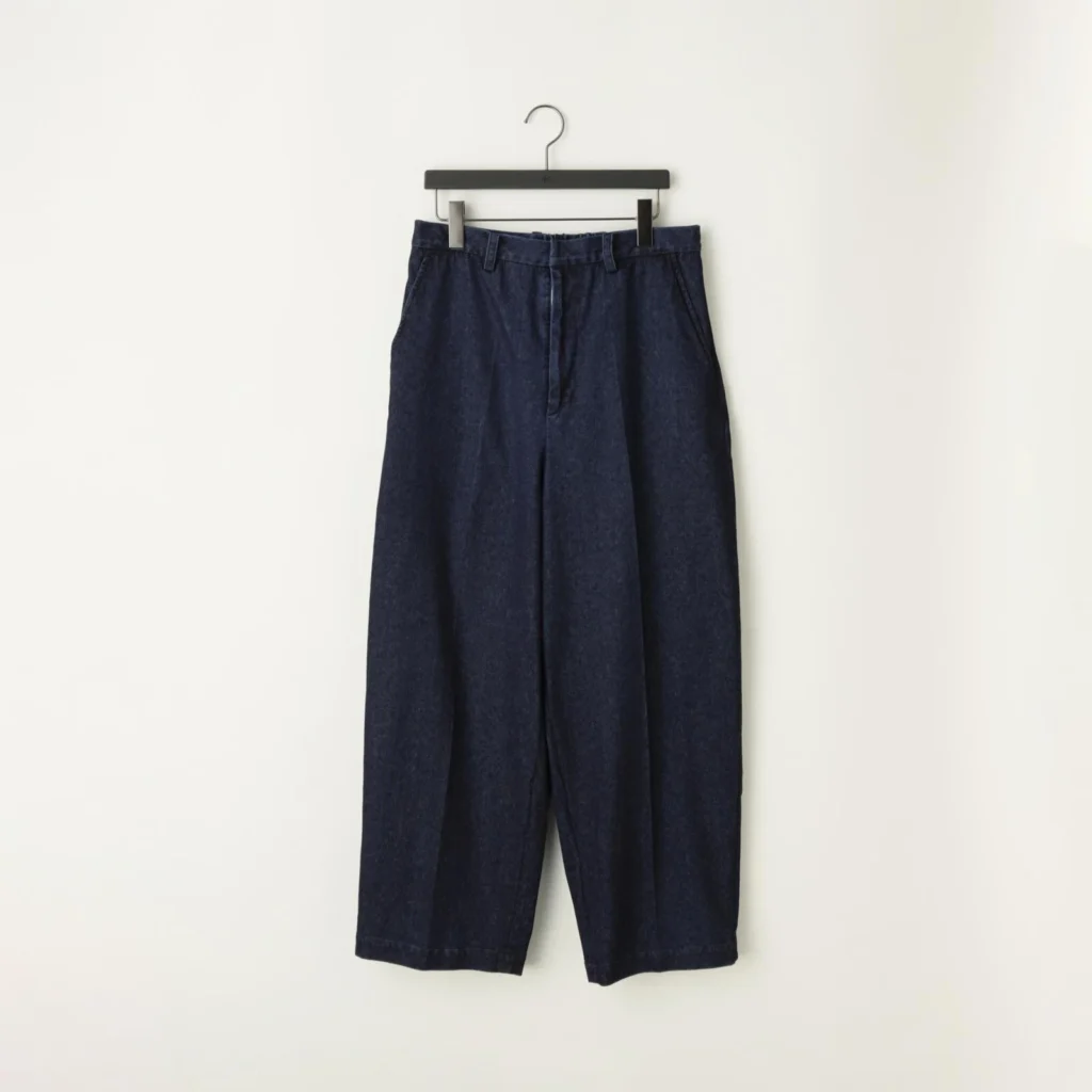 Dark indigo wide-leg denim trousers featuring a high-rise waist, clean front, belt loops, side pockets, straight oversized leg, cropped length, and minimalist workwear-inspired tailor