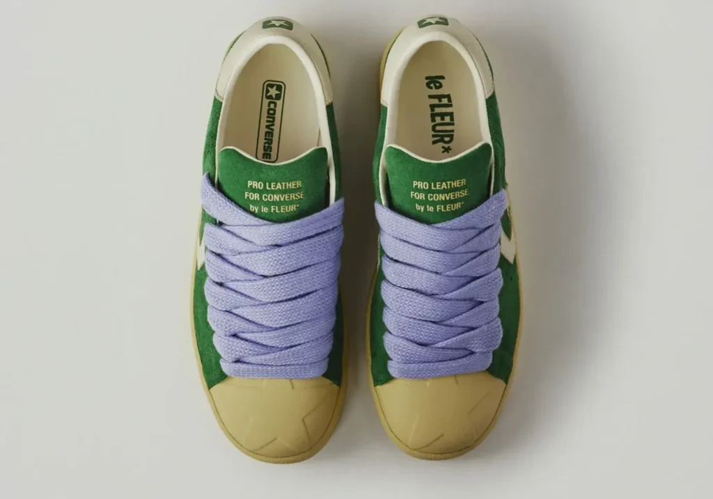 Top-down view of the green suede Converse Pro Leather by le FLEUR* showcasing oversized lavender rope laces, cream lining, and gold tongue brand