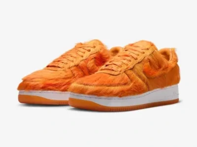 Angled pair of the orange furry Nike Air Force 1, showcasing the textured upper, sculpted Swoosh, and classic low-top sil
