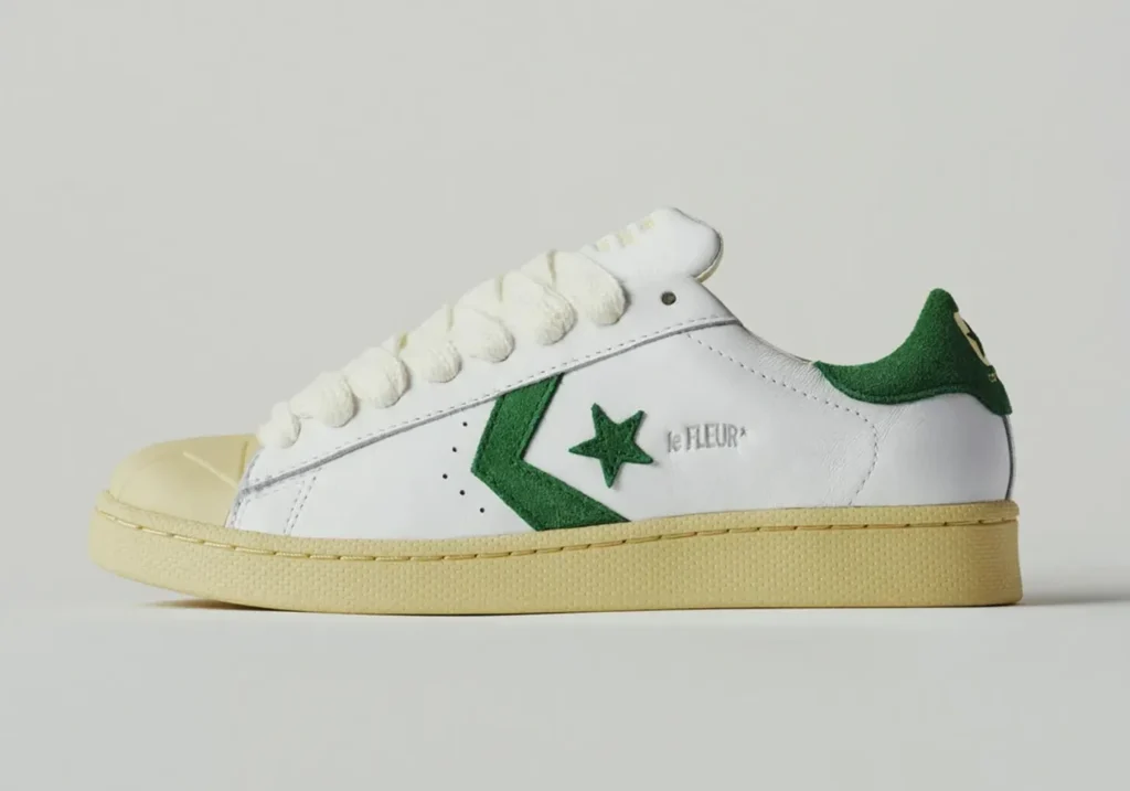 Lateral side profile of the white leather Converse Pro Leather by le FLEUR* featuring a green suede Star Chevron logo, oversized cream rope laces, cream toe cap, and aged midsole