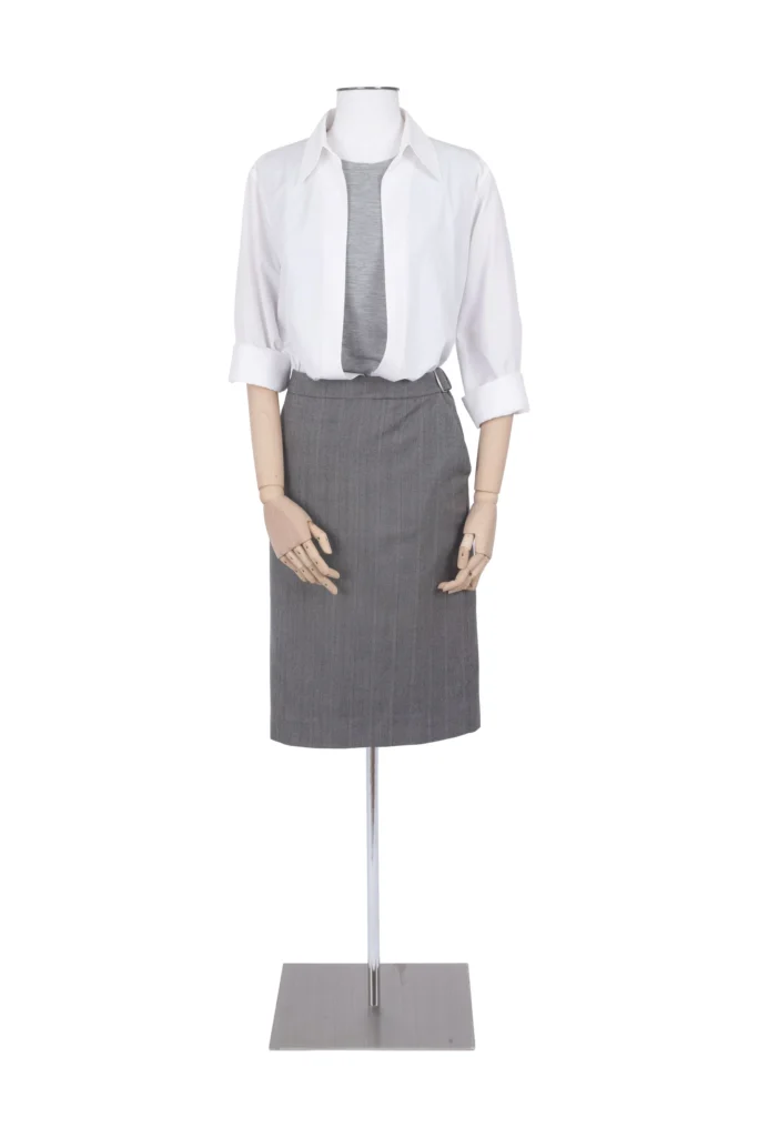 Minimalist styling look featuring a crisp white button-up shirt layered over a gray top and paired with a tailored gray pencil skirt on a mannequin