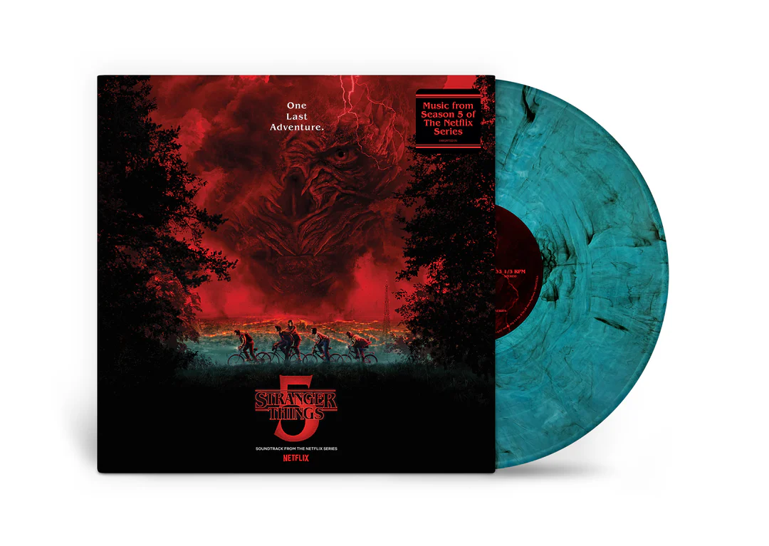 The Stranger Things 5 soundtrack vinyl in a blue smoke pressing partially slides out of its sleeve, revealing cover art of the Hawkins crew cycling beneath a towering red sky dominated by Vecna. The packaging features the Stranger Things 5 logo and Netflix branding against a clean white background.