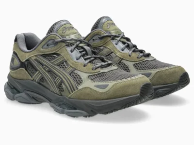 Pair of olive green and dark gray ASICS GEL-NYC shoes shown from a front three-quarter angle, highlighting the mesh toe boxes, suede overlays, gray laces, and layered midsole