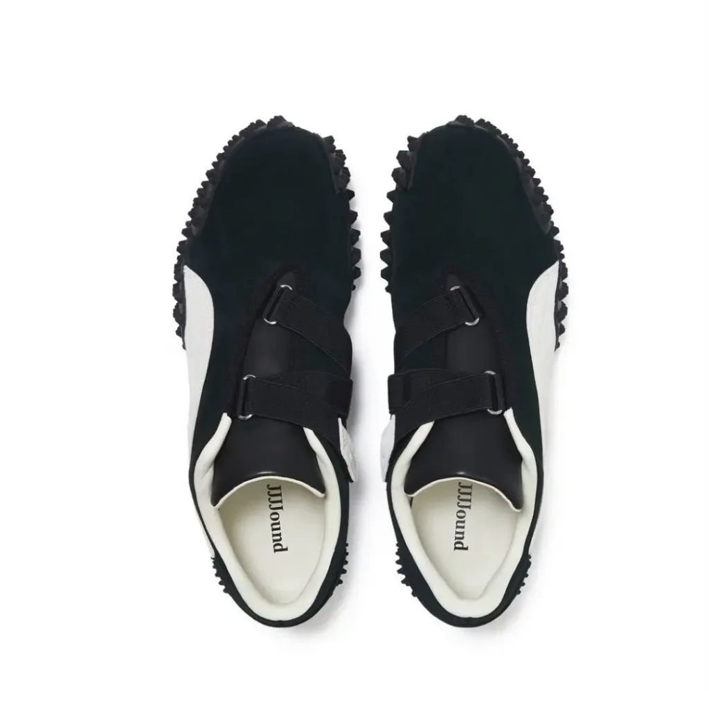 Top-down view of black suede Puma x JJJJound shoe showing dual black velcro straps, white Formstrip edges, and “JJJJound” printed on the white insole