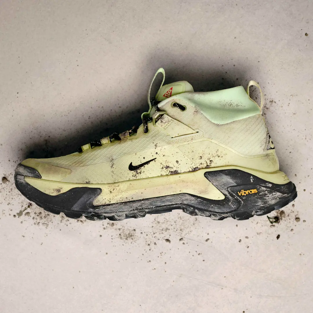 Nike ACG Zegama Hike trail shoe in the Life Lime colorway after an off-road run, with mud splattered across the upper, ZoomX midsole, and Vibram outsole to showcase its rugged all-terrain performance.