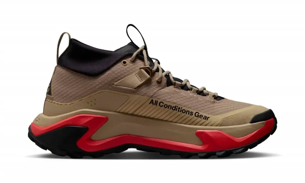 Medial side profile of the Nike ACG Zegama Hike displaying the 'All Conditions Gear' branding, khaki mesh upper, and sculpted red-and-black trail mid