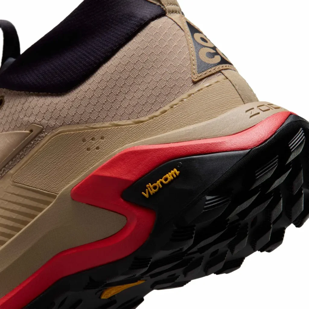Detailed close-up of the Nike ACG Zegama Hike heel showing the red sculpted midsole wrap, Vibram logo, and aggressive outsole lug pattern