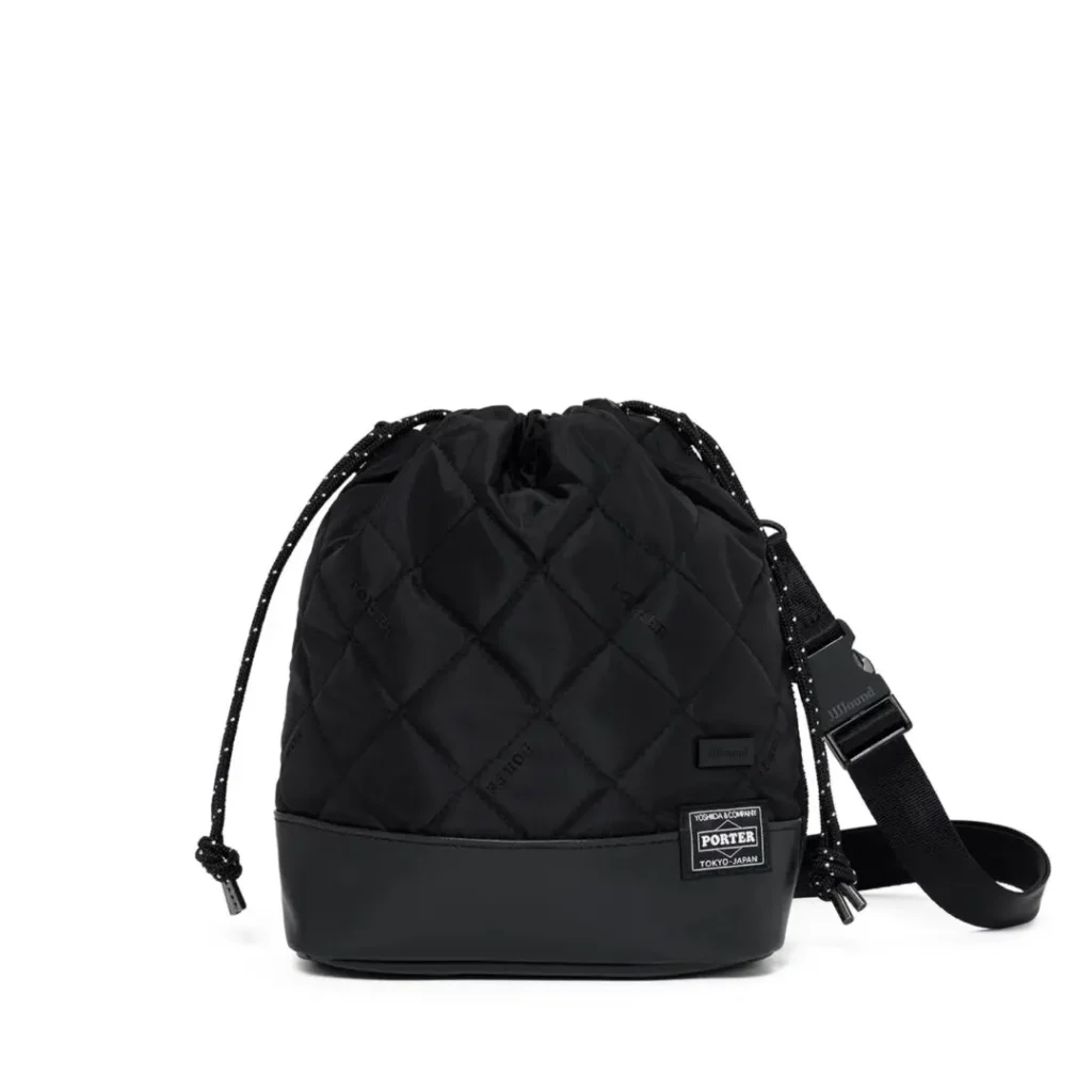 A quilted black PORTER drawstring bucket bag features a detachable shoulder strap, diamond-stitched construction, reinforced base, and signature woven logo patch on a white background