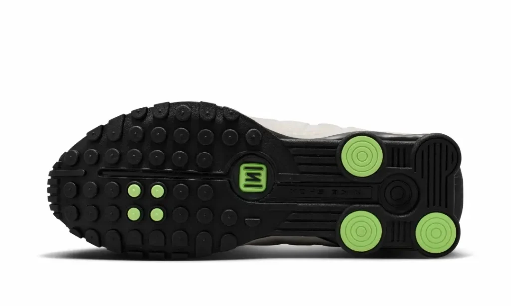 Outsole view of the Nike Shox TL showing the black rubber traction pattern with lime green cushion and pivot detail